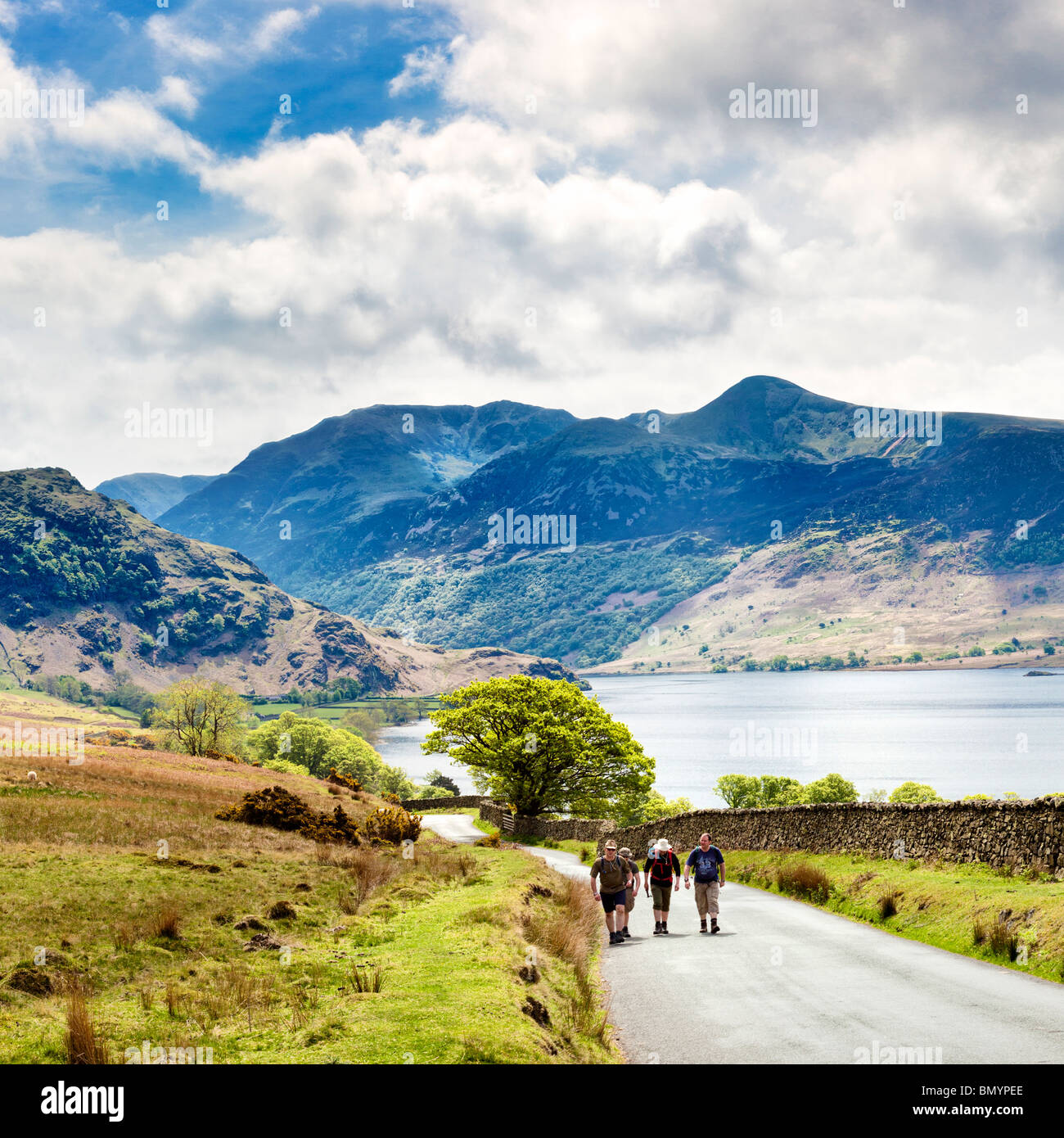 Hikers walking past Crummock Water, Lake District, England, UK with High Stile and Red Pike Stock Photo