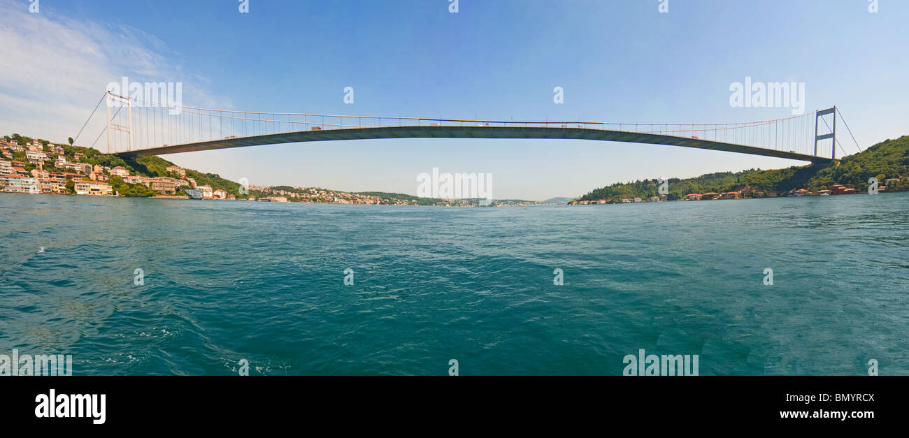 Ataturk suspension bridge spanning the Bosphorus river in Istanbul, Turkey against a blue sky