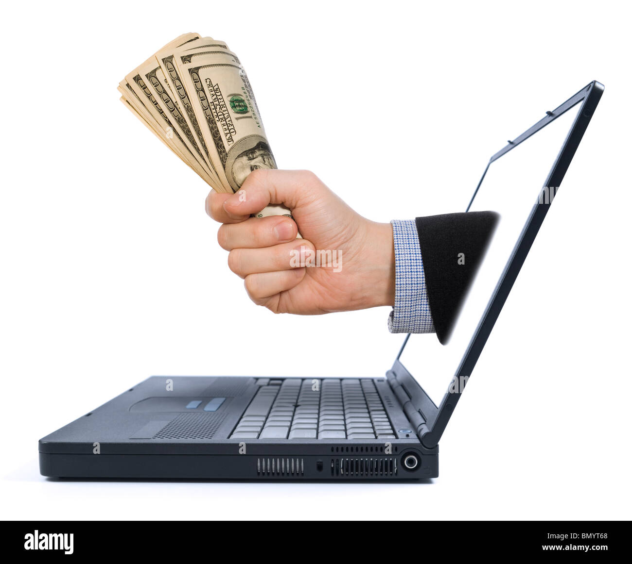 A fistful of dollars appears from the laptop screen. Stock Photo