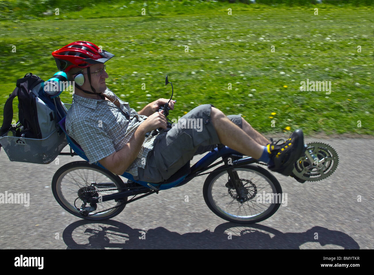 Recumbent Cycling on picnic through the park while listening to music Stock Photo