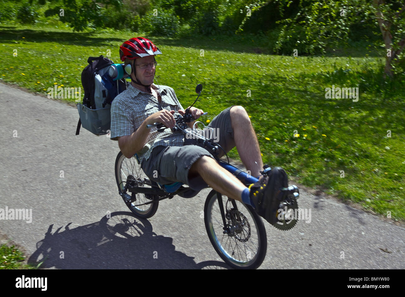 Recumbent Cycling on picnic through the park while listening to music. Horizontal Stock Photo