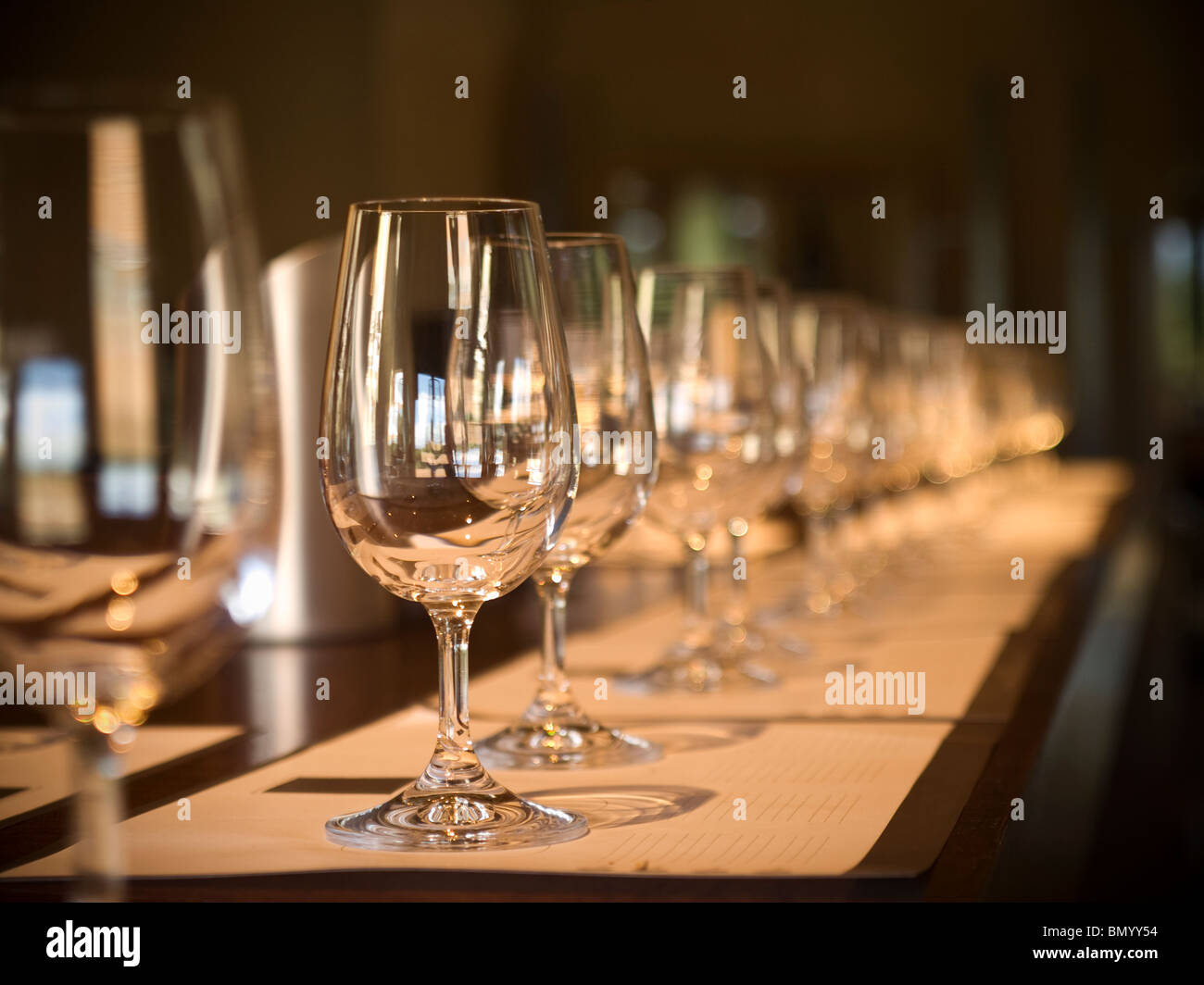 A long row of empty glasses before the wine tasting starts. Selective focus. Stock Photo