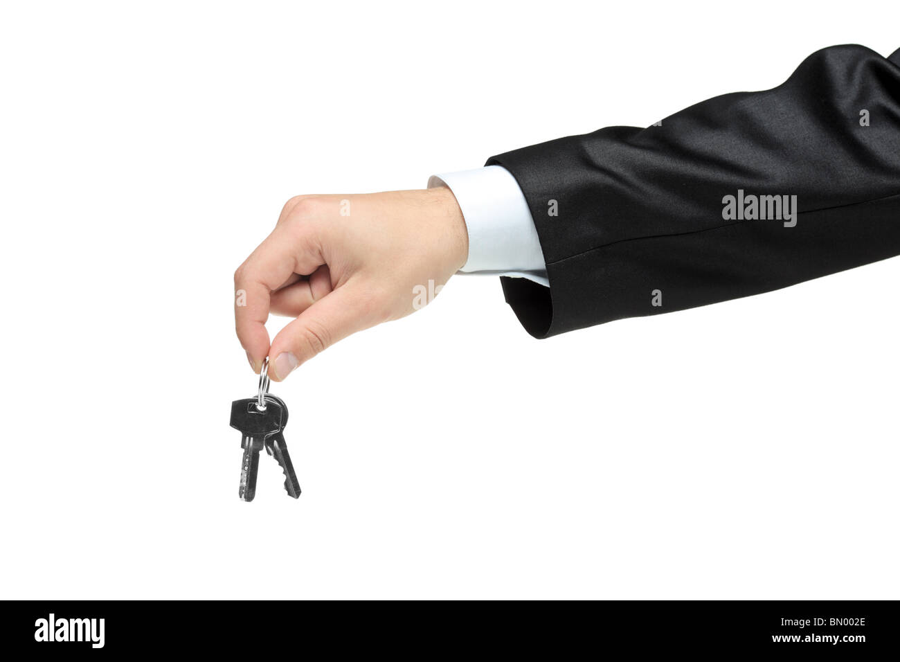 Man in a black suit holding keys Stock Photo Alamy