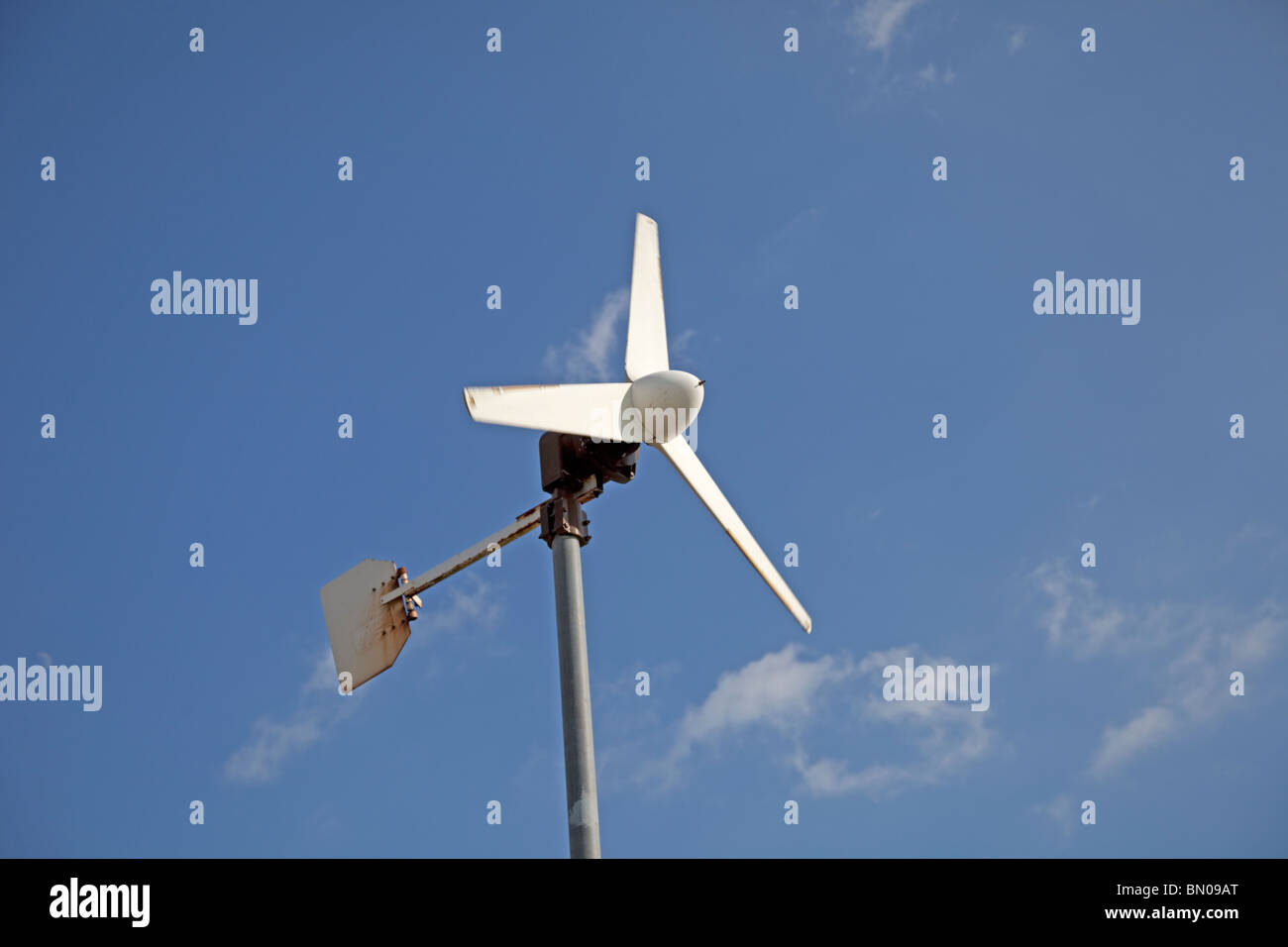 Small wind turbine against blue sky North Devon UK Stock Photo