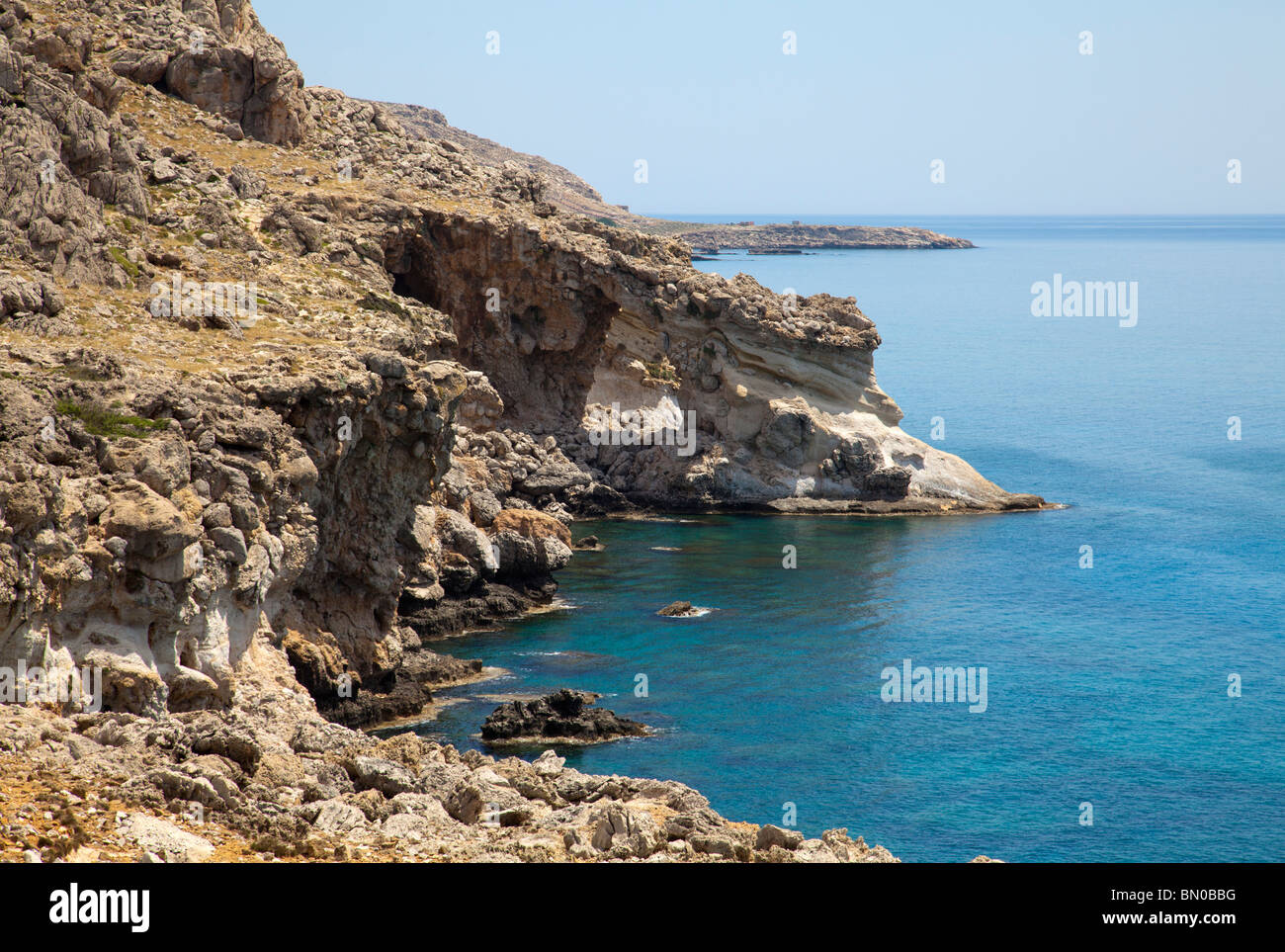Rocky coastline with natural arch and blue mediterranean waters Stock Photo