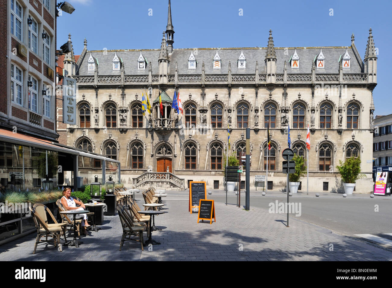 The medieval City Hall and tourists enjoying a drink at pavement café on the main square, Kortrijk, Belgium Stock Photo