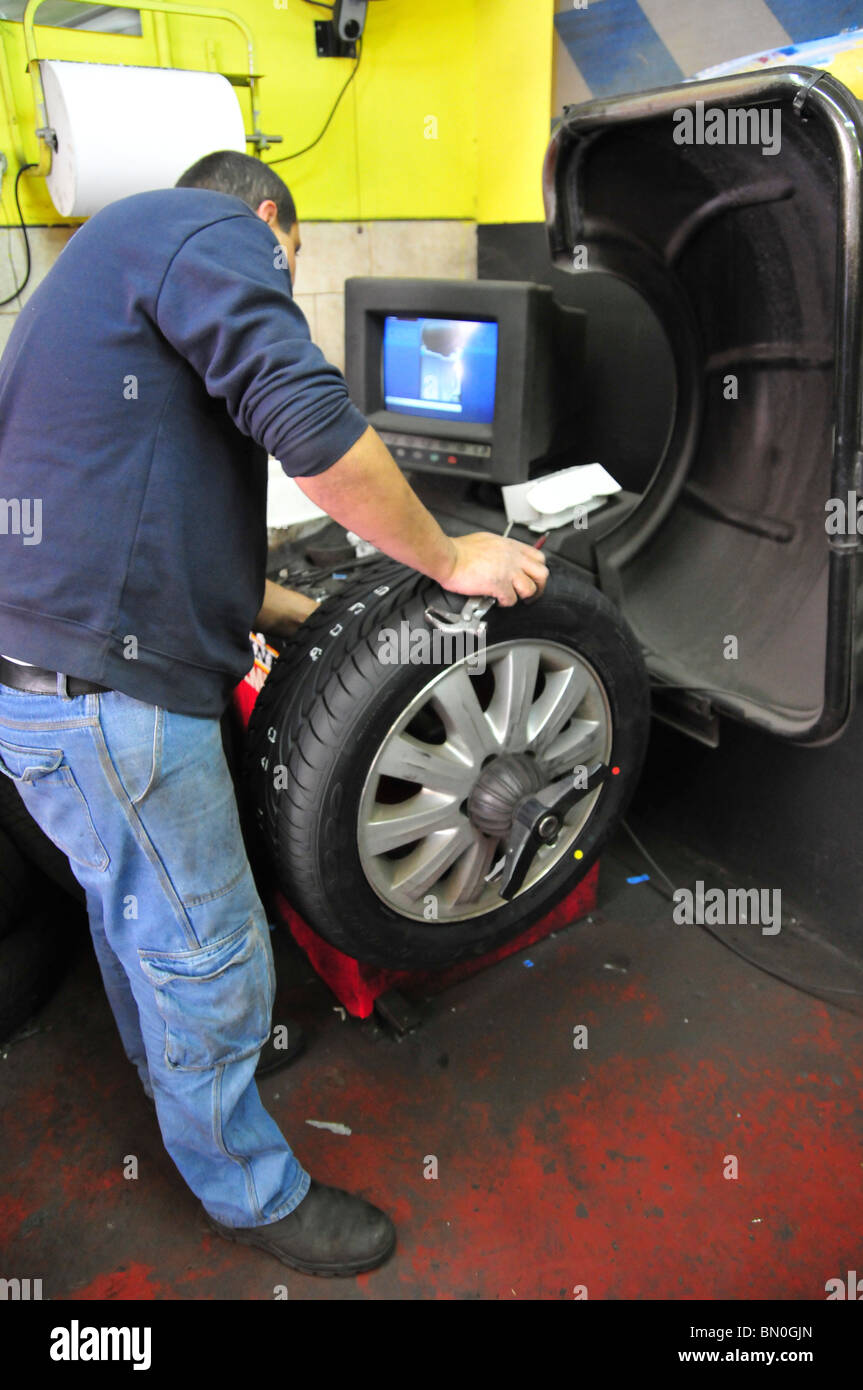 Mechanic balances a new tyre placed on a car wheel Stock Photo Alamy