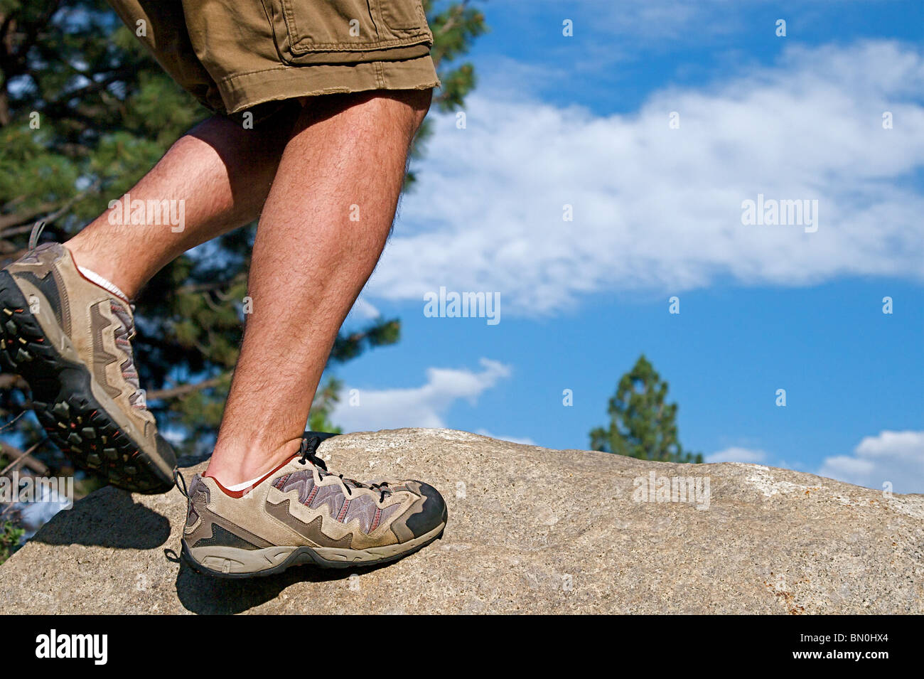 Trail runner climbing a steep rock in his path Stock Photo Alamy