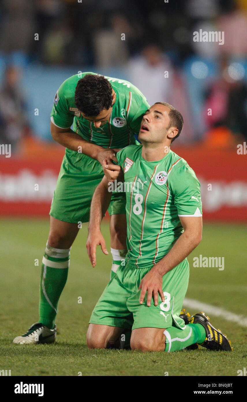 Algeria team captain Anther Yahia (l) helps teammate Medhi Lacen (r) to his feet after Algeria lost to the USA late in the match Stock Photo