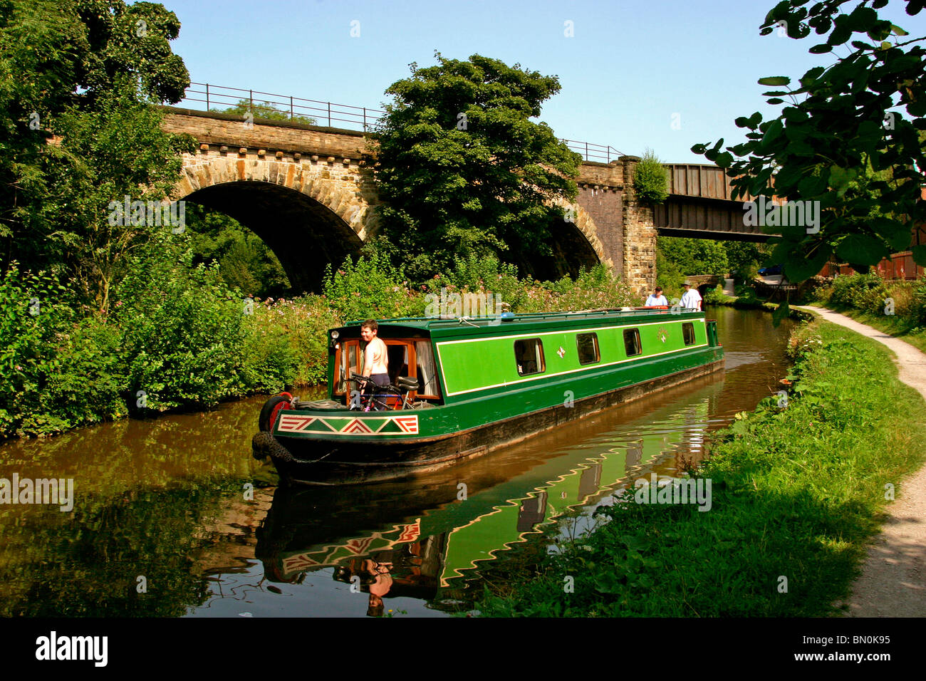 UK, England, Cheshire, Stockport, Marple, narrowboat on Peak Forest Canal viaduct, alongside railway bridge Stock Photo