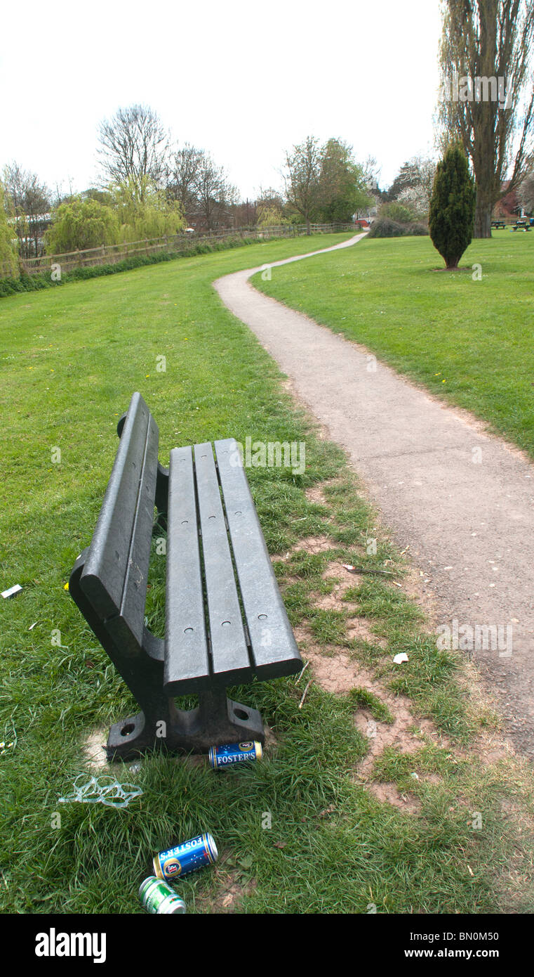 Park bench with empty lager cans littered around it. Stock Photo