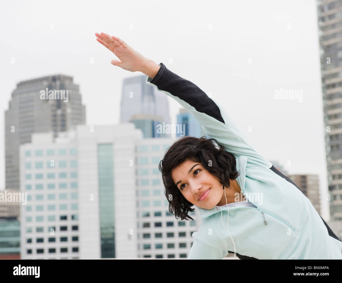 Hispanic woman stretching in city Stock Photo
