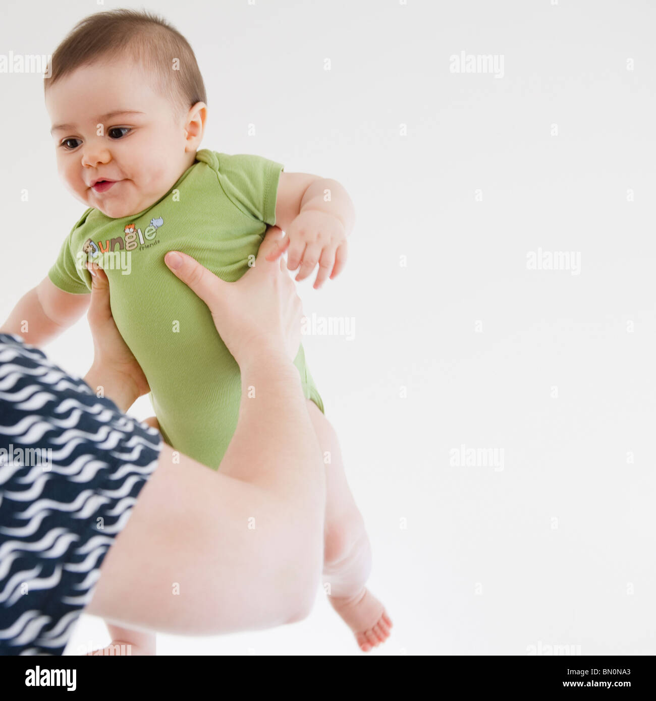Mother lifting mixed race baby boy Stock Photo