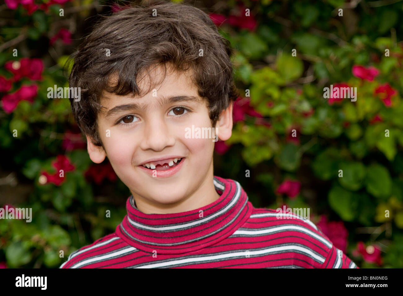 young 6-7 year olds Persian/Iranian heritage boy with two front teeth missing.   MR  © Myrleen Pearson Stock Photo