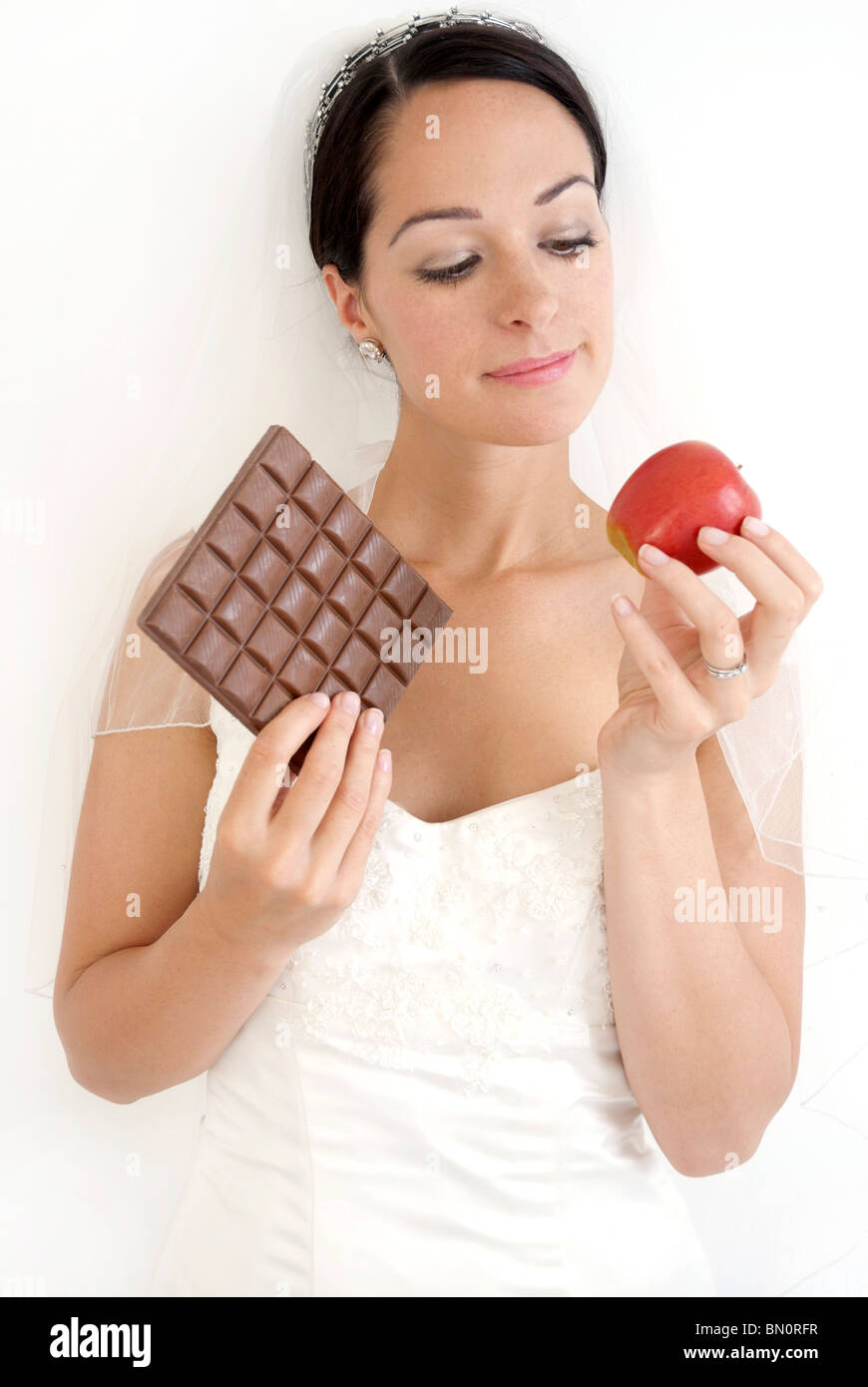 A bride to be who is tempted with good and bad food Stock Photo