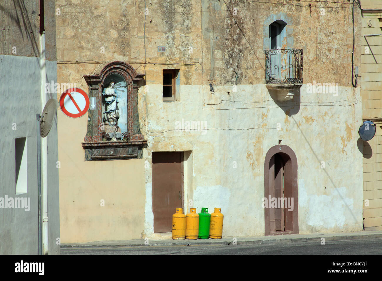 A line of yellow and green gas canisters stand outside a door to a
