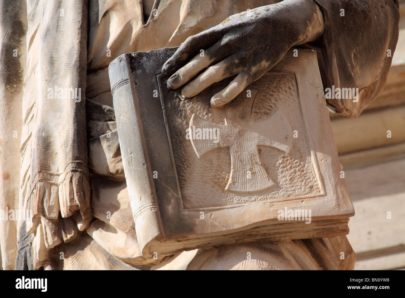A hand on the bible from a statue outside The Church of St Mary, better known as the Mosta Dome or Rotunda, Malta Stock Photo