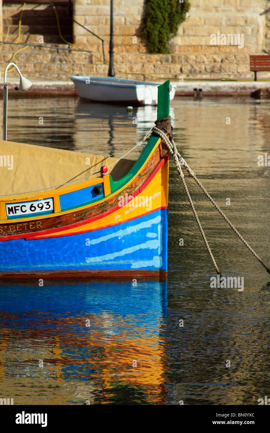 A multi colored luzzu or traditional fishing boat at harbour in Marsaxlokk, Malta Stock Photo