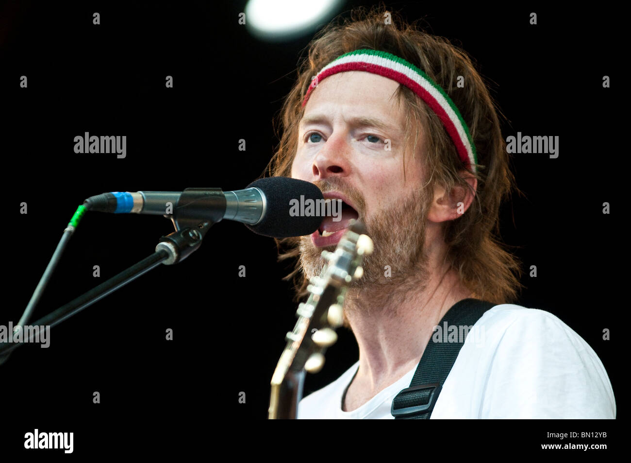 Thom York, special guest at Glastonbury 2010 performing live and singing into a microphone Stock Photo