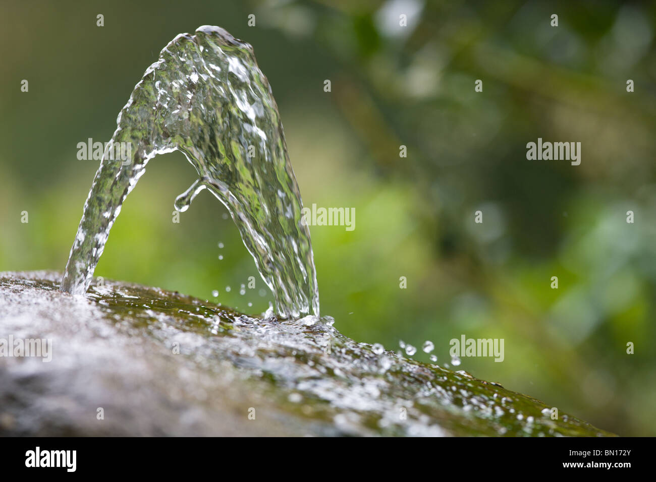 water fountain emerging a stone closeup Stock Photo