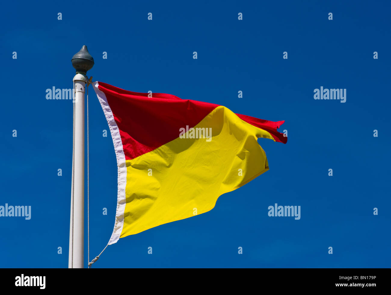 UK Red And Yellow Beach Flag Lifeguard on duty. Stock Photo