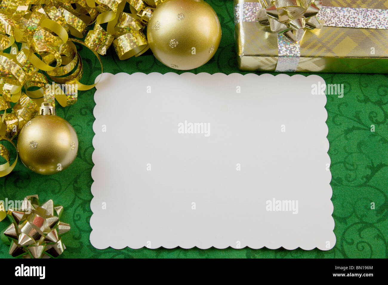 blank Christmas card with gold baubles, curly metallic ribbon, bow, present and copyspace Stock Photo
