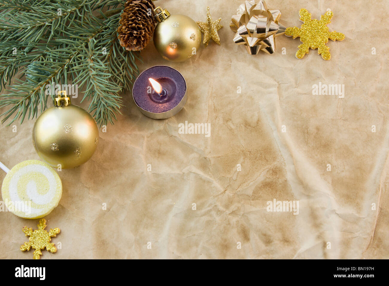 Christmas corner frame with purple tea light, fir branch, gold elements on antique paper with copyspace Stock Photo