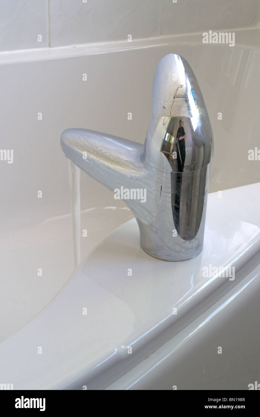 Close Up Of Chrome Mixer Tap Turned On Filling a Bathtub Stock Photo