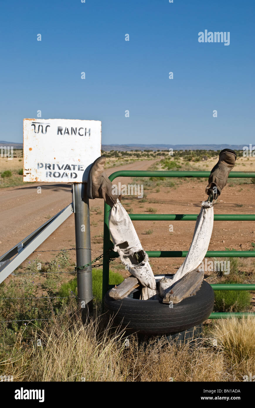 A humorous, but also ominous warning is posted at the gate to a private ranch north of Carrizozo, New Mexico. Stock Photo