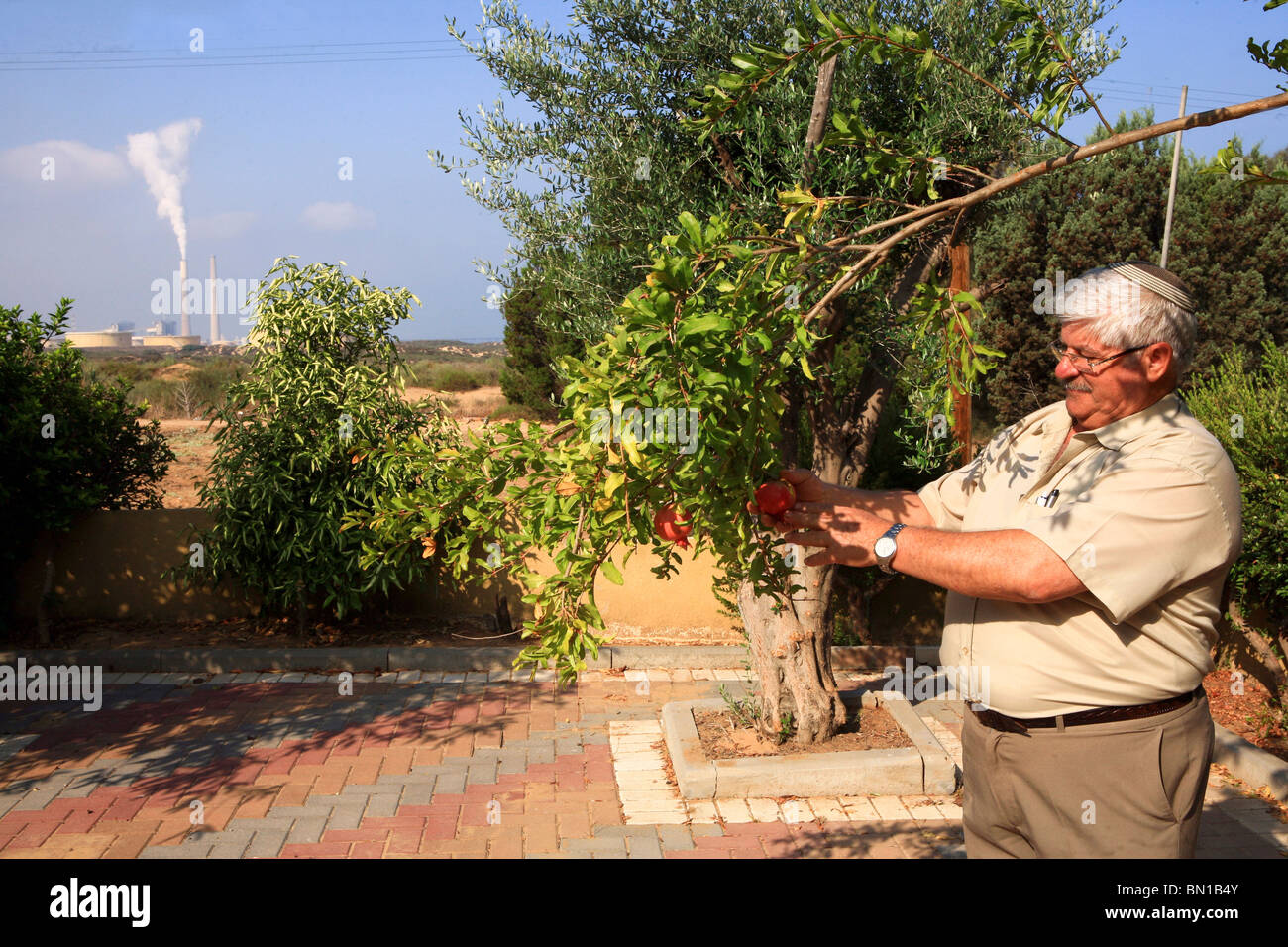 Israel, Hadera, The smoke emitting coal operated power plant's flues as seen from a residence's home Stock Photo