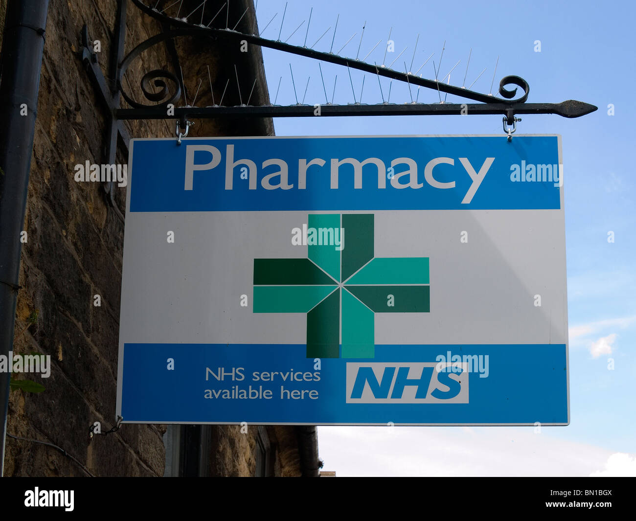 Sign outside a Pharmacy with a green cross and the caption - NHS services available here Stock Photo
