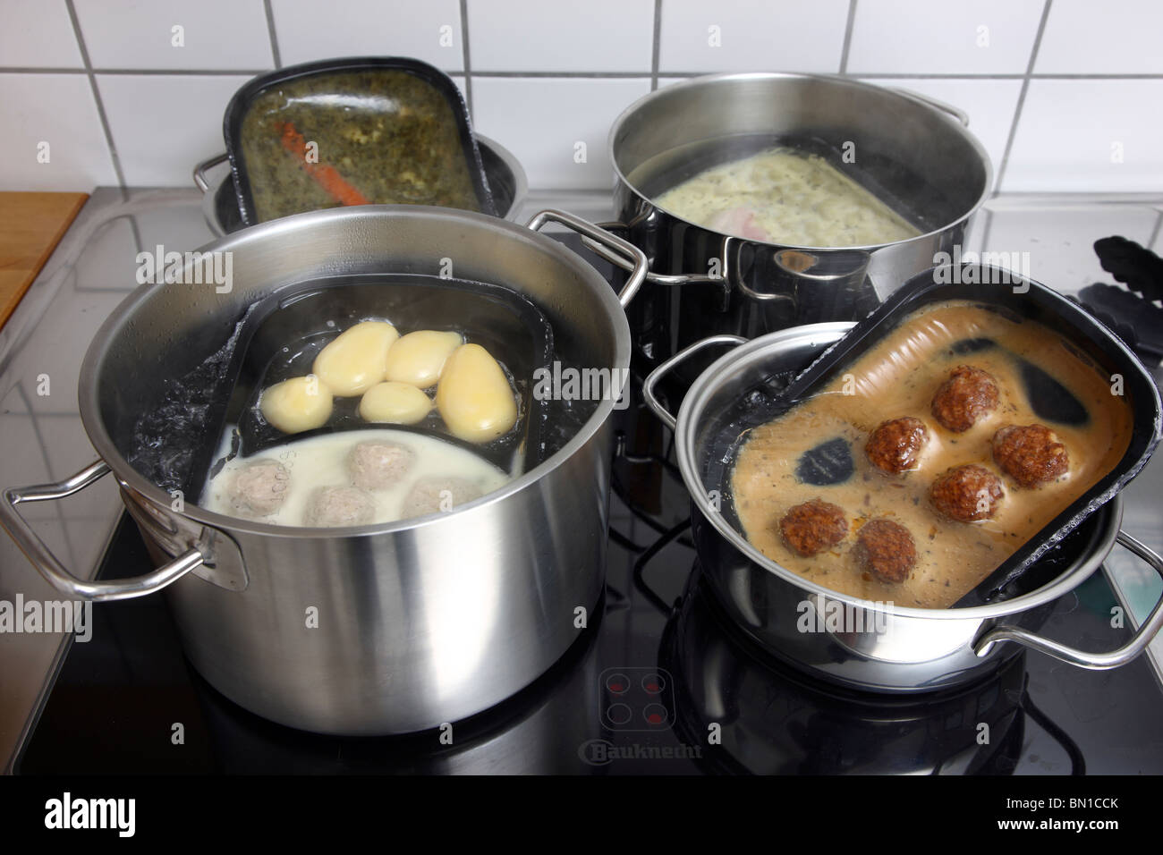 Heating of ready-to-serve meals in hot water. Convenience food products from a supermarket. different dishes, ready to eat. Stock Photo