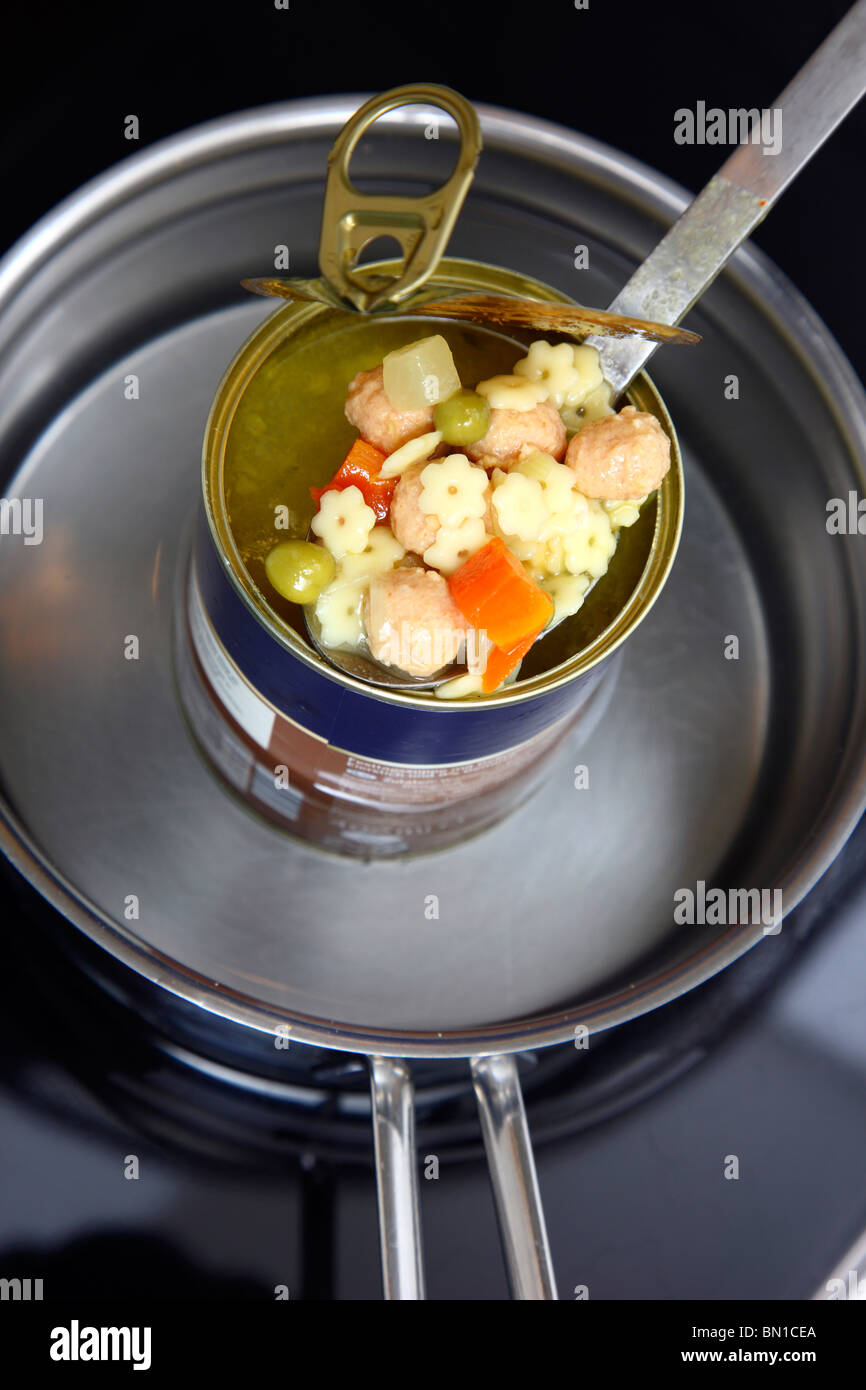 Heating of ready-to-serve meals in hot water. Soups or pasta dishes in cans. Convenience food products. Stock Photo