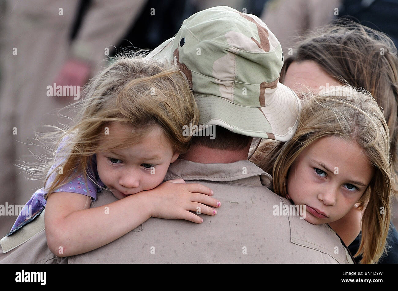 1st. Lt. William Jacks, 34th Bomb Squadron B-1 pilot, hugs his daughters Rachel (left) and Anna at Ellsworth Air Force Base Stock Photo