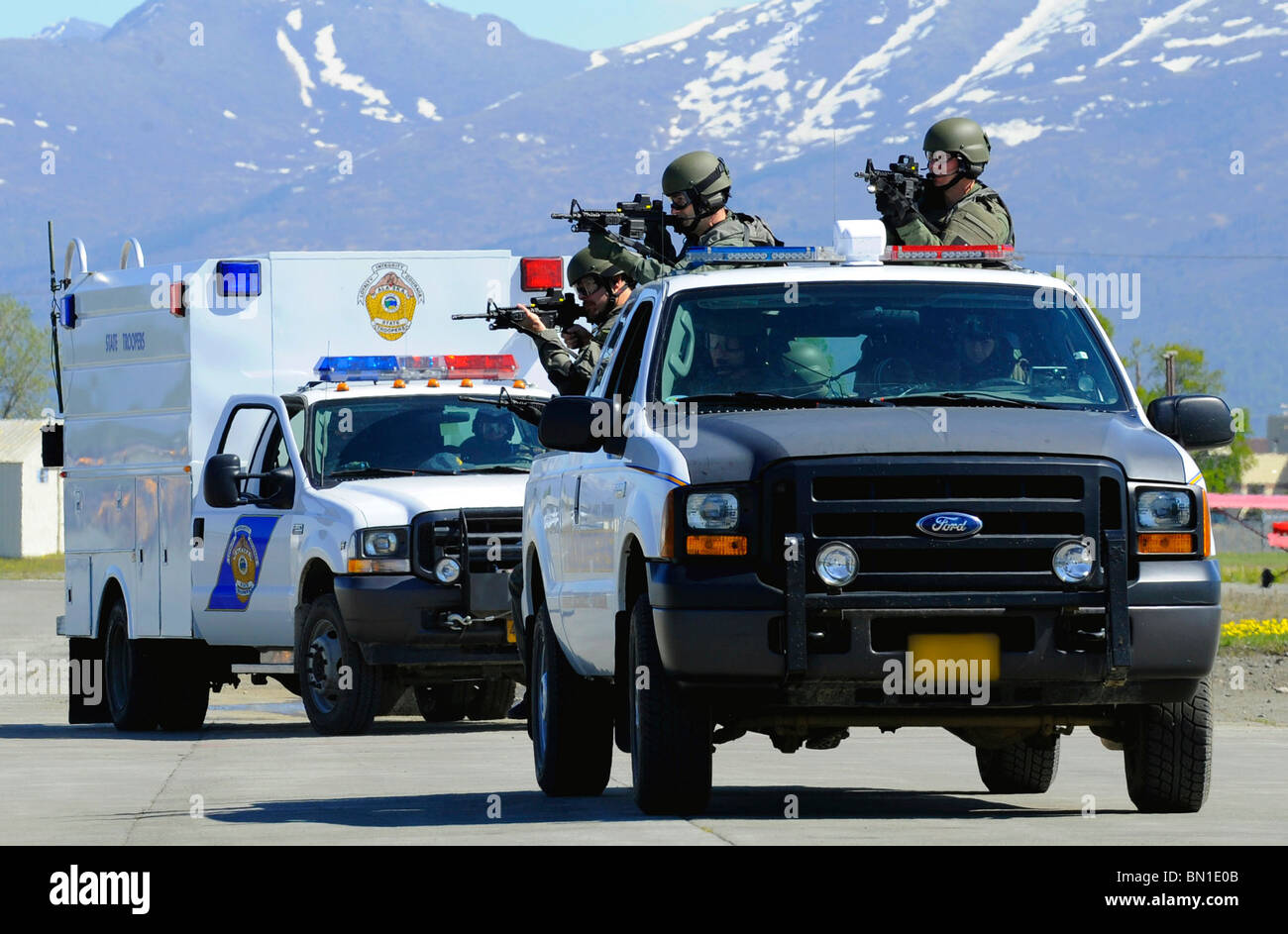 An FBI and Alaska State Trooper joint SWAT team move toward an aircraft during Arctic Fencing Interagency Arrow 2010 field train Stock Photo