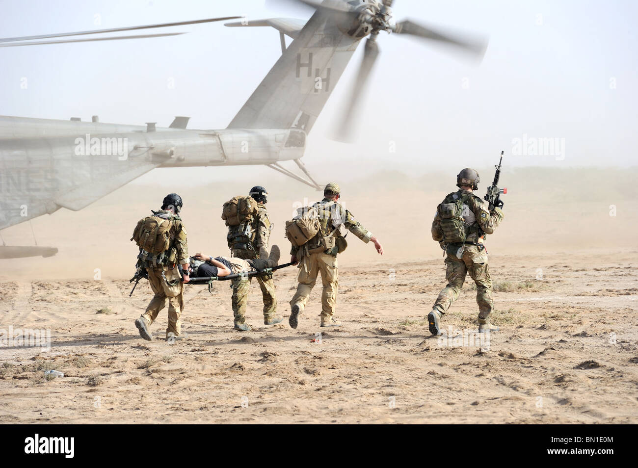 Air Force pararescuemen transport an injured 'victim' to a waiting U.S. Marine Corps MH-53 Super Stallion during exercises. Stock Photo