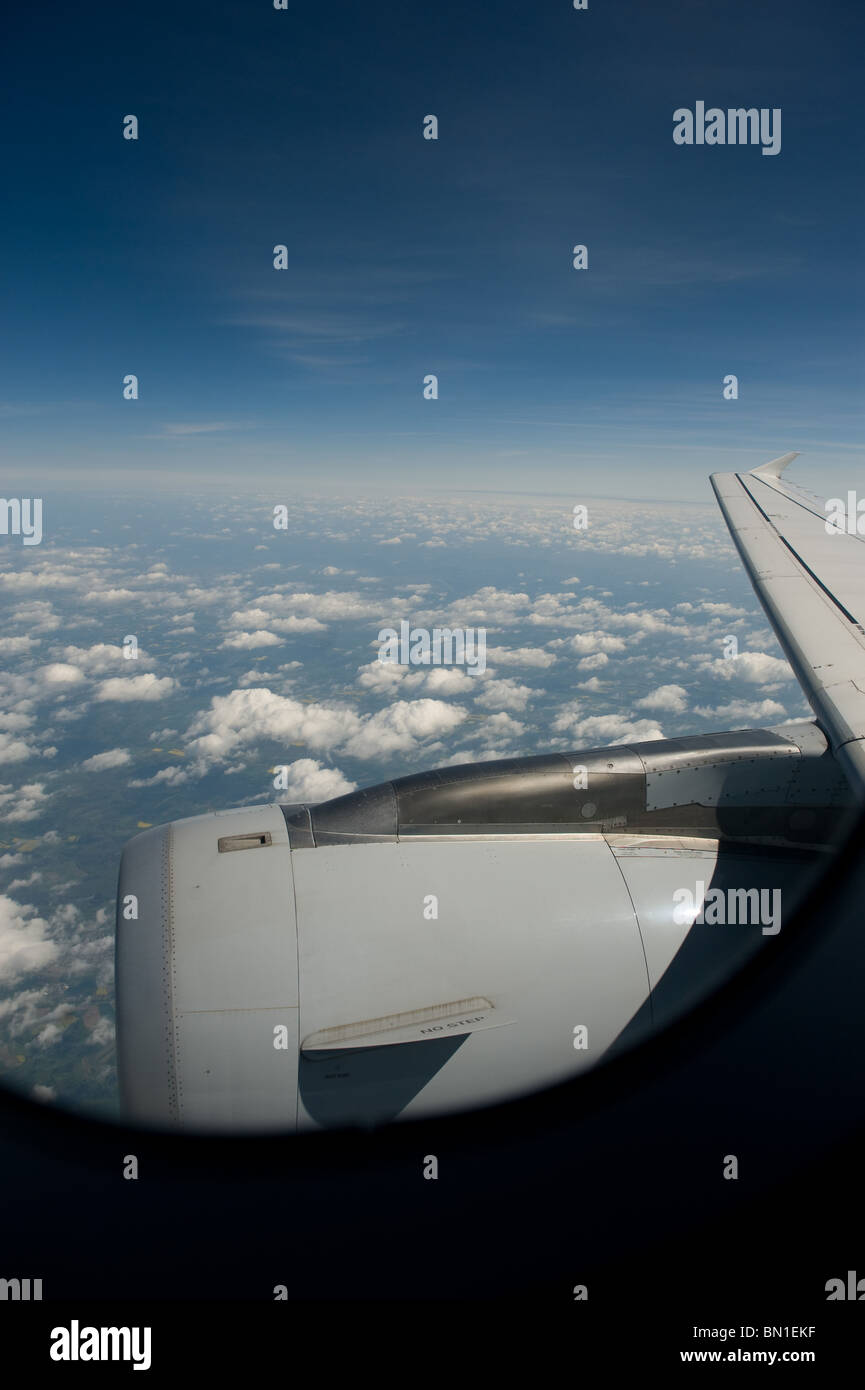 The view through the window of a commercial airliner showing blue sky and the jet engine of the plane, Europe 2010 Stock Photo