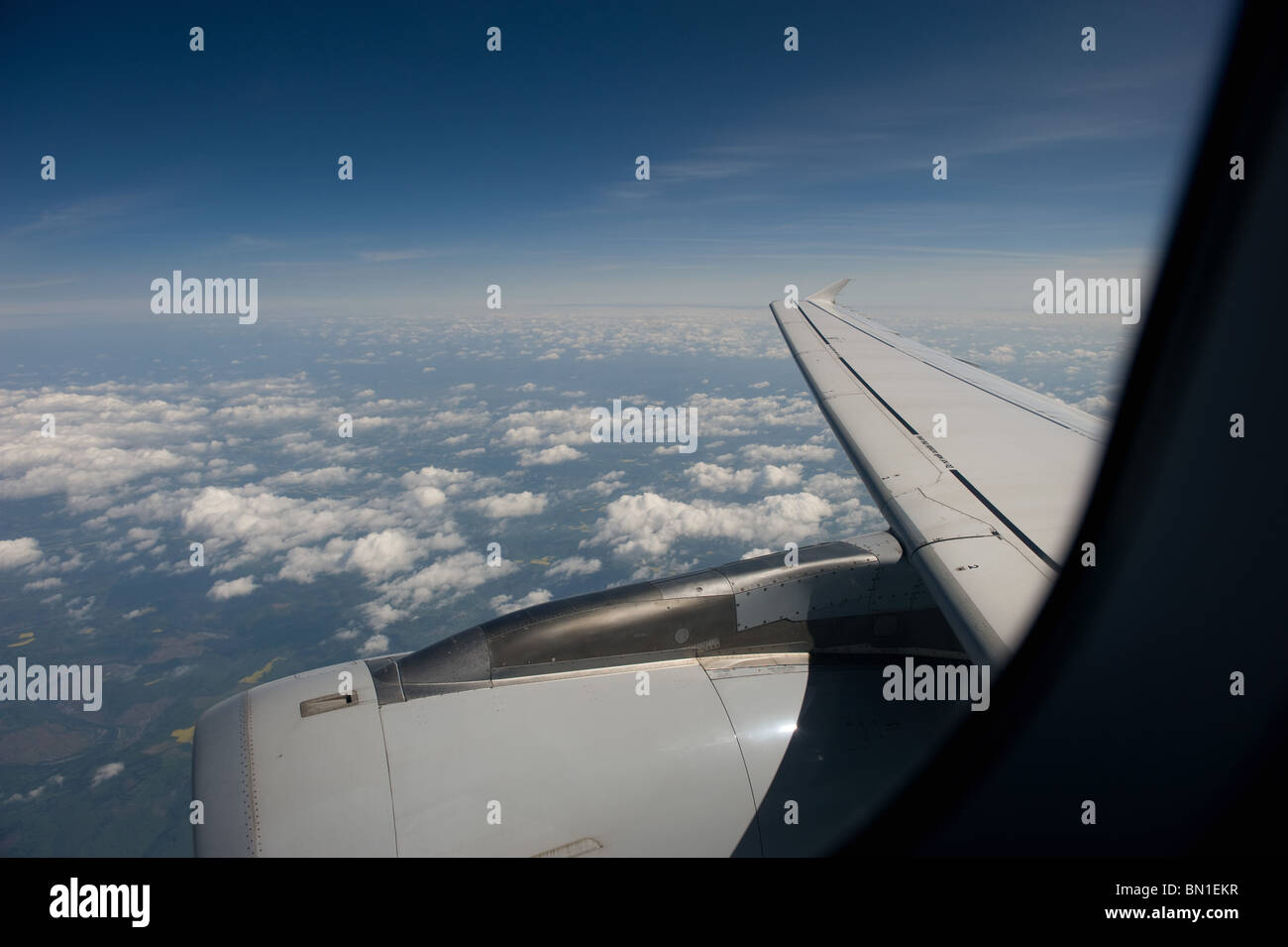 The view through the window of a commercial airliner showing blue sky and the jet engine of the plane, Europe 2010 Stock Photo