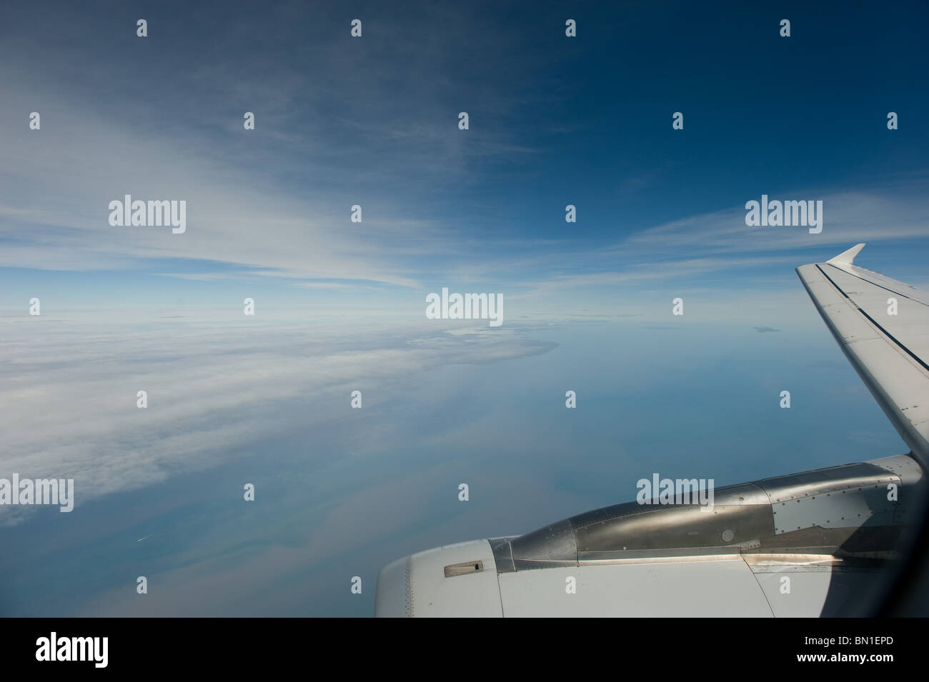 The view from the window of a passenger jet showing the engine and wing with a blue sky, Europe 2010 Stock Photo