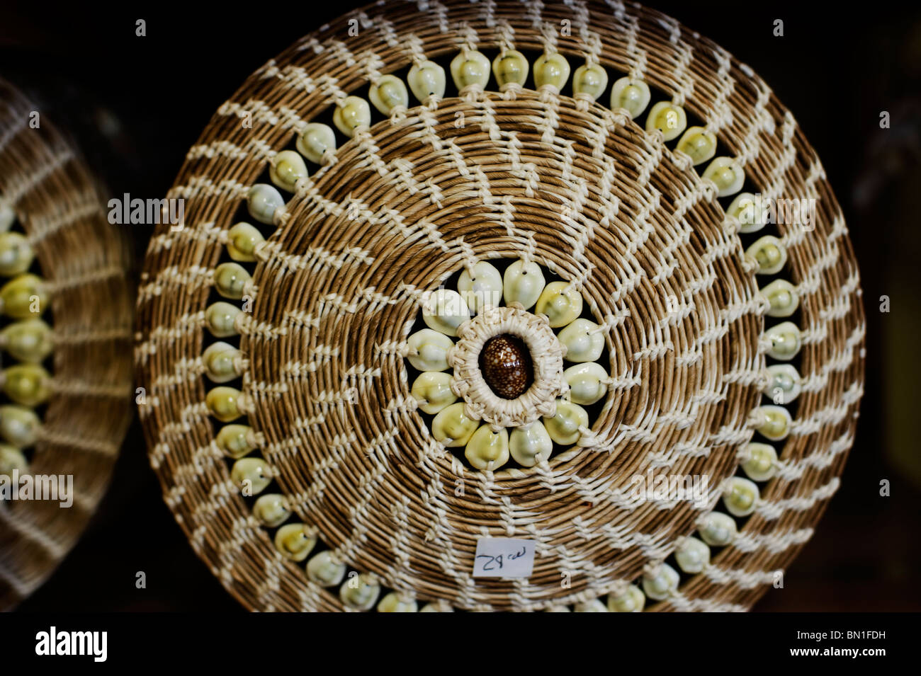 A traditional woven basket decorated with kauri shells at a shop in Majuro, Majuro Atoll. Stock Photo