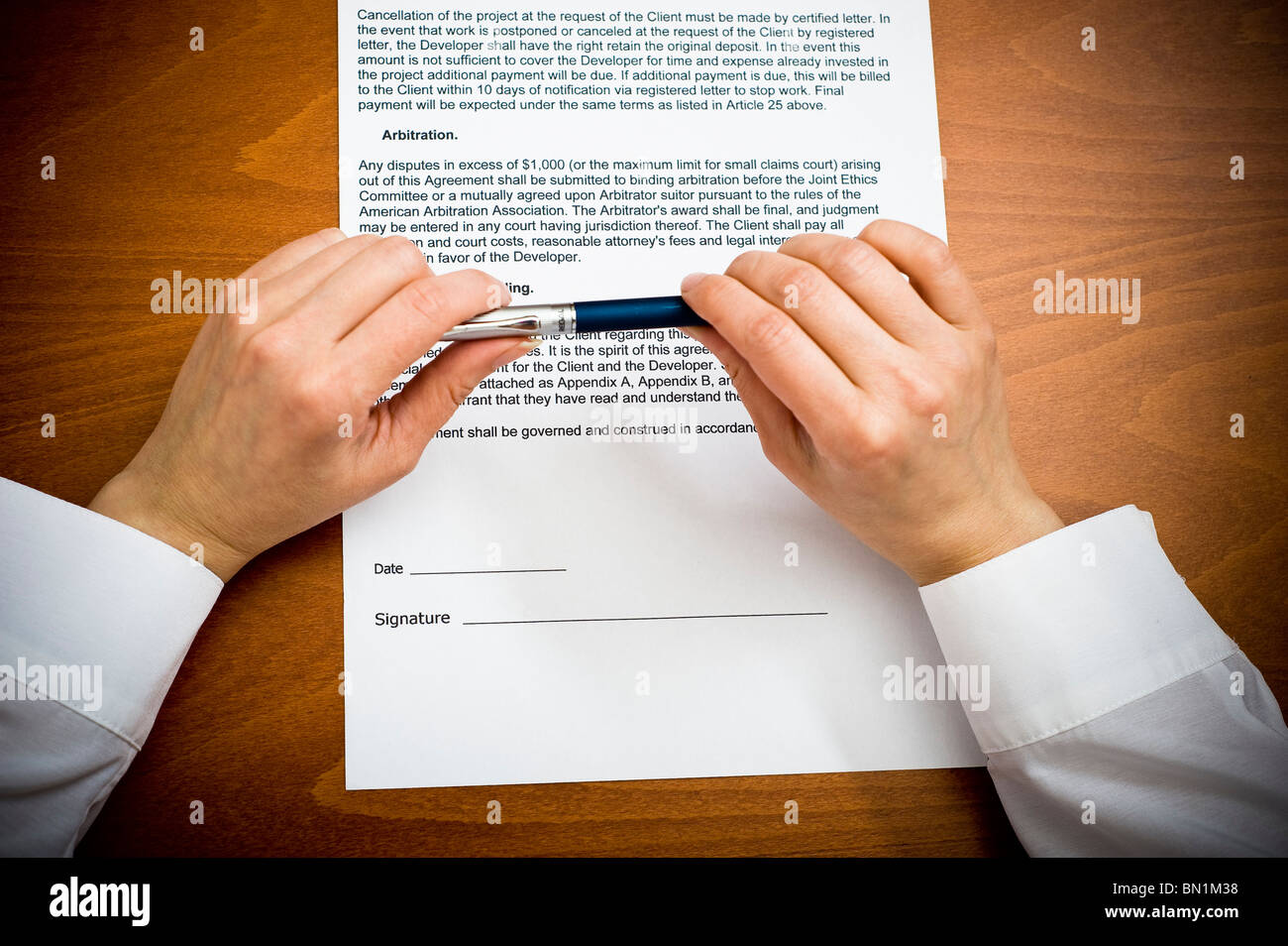 woman's hands holding a pen over a contract Stock Photo