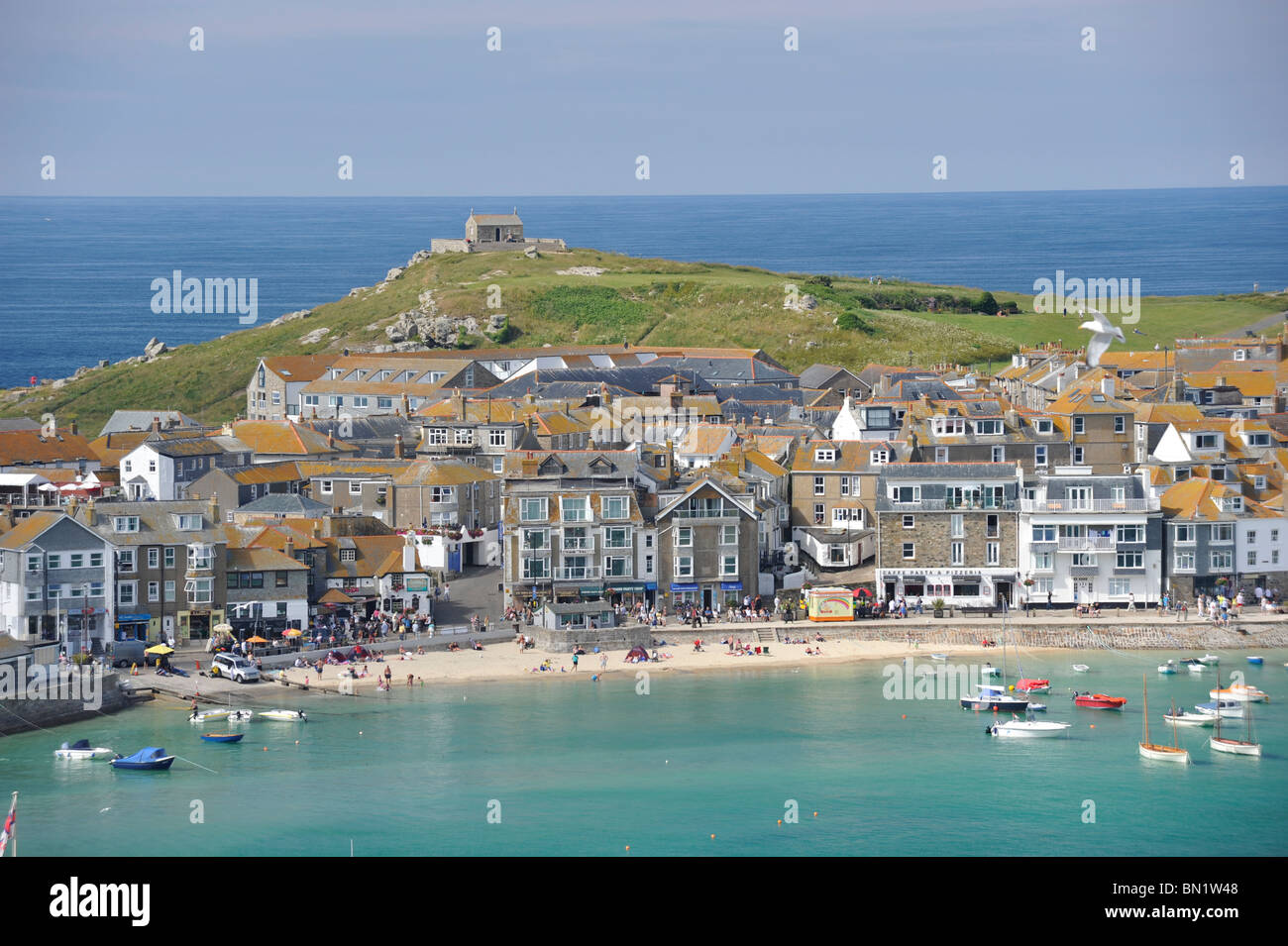 Elevated view of St Ives Harbor and beach in Cornwall with St Nicholas' Chapel on the hill behind. Stock Photo