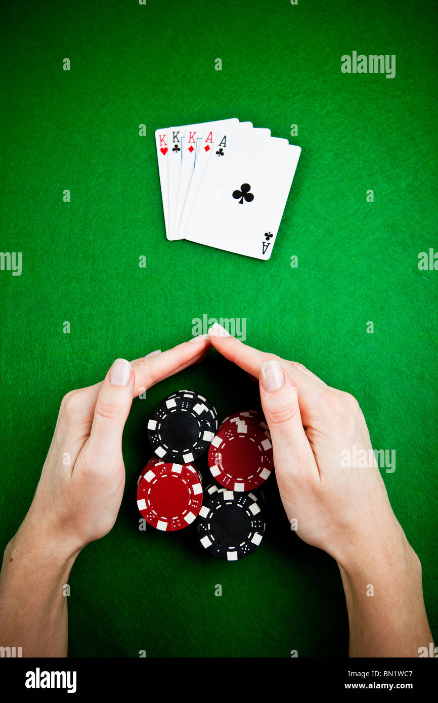 Female hands rakes up stack of gambling chips Stock Photo