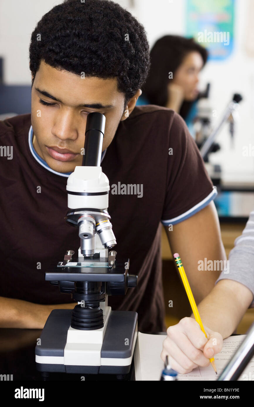 High school student looking through microscope Stock Photo Alamy