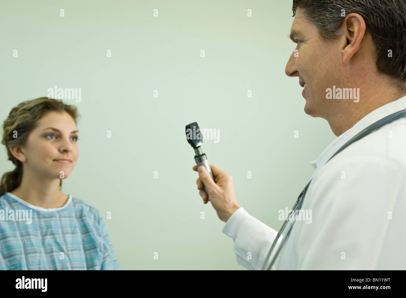 Doctor with ophthalmoscope conducting medical exam Stock Photo
