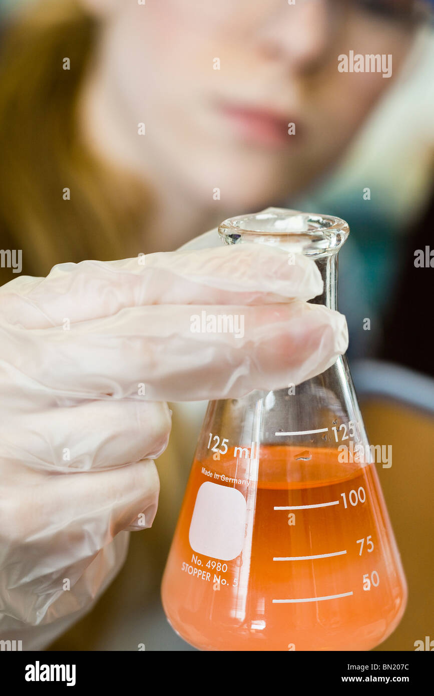 Researcher holding beaker filled with chemicals Stock Photo Alamy