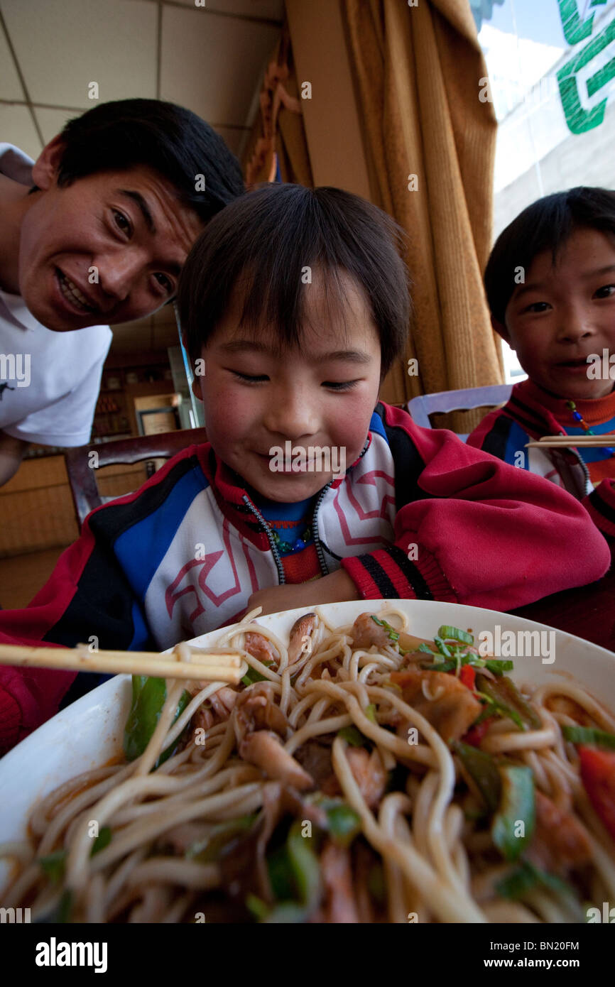 Boy eating noodles in Shigatse, Tibet Stock Photo