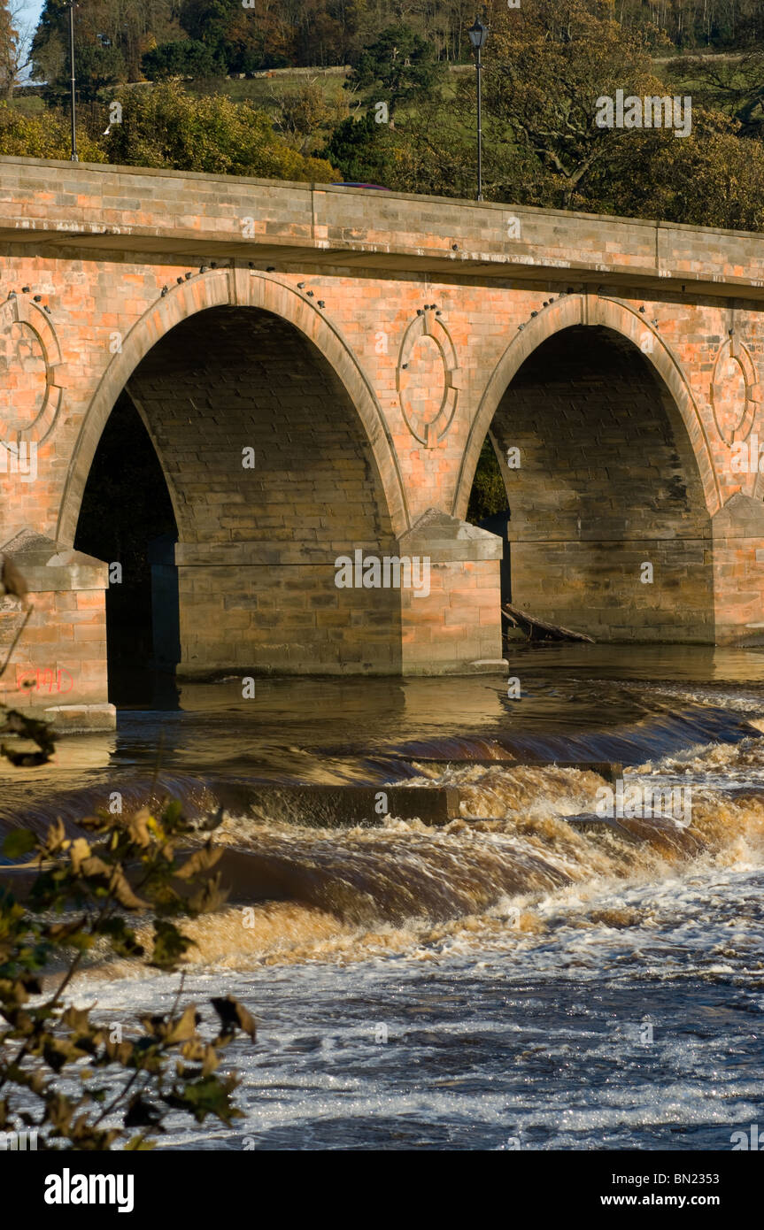 Middle two arches of Hexham stone bridge and weir from south side of river downstream Stock Photo