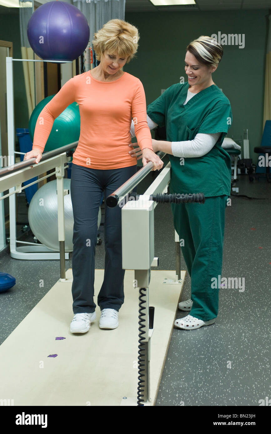 Woman undergoing post-surgery rehabilitation exercises to regain ability to walk Stock Photo