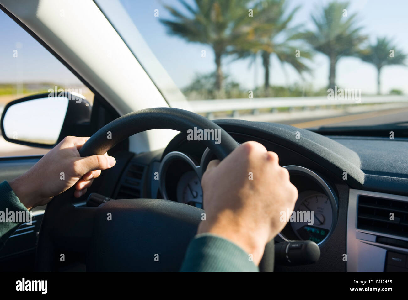 Driving with both hands on steering wheel Stock Photo